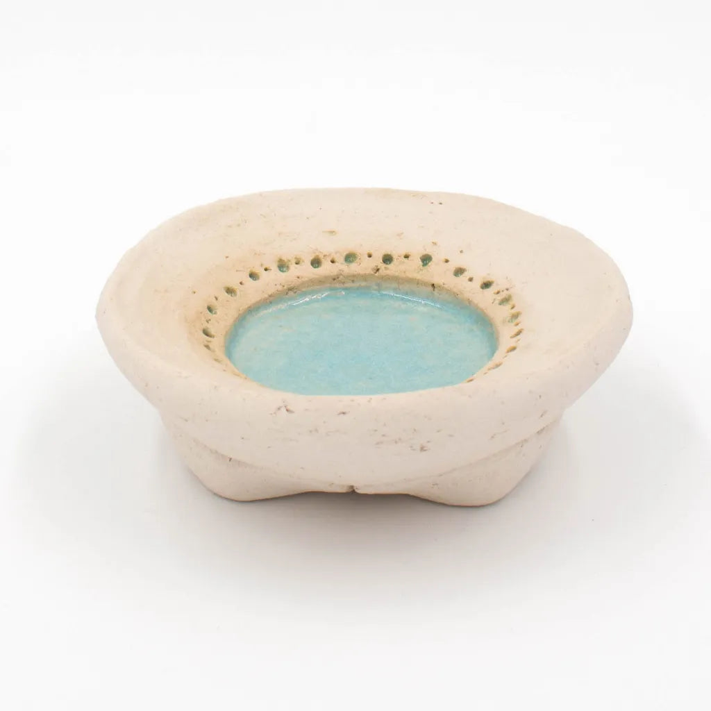 Handgetöpferter Kerzenteller mit türkis-farbener Glasur und einzigartiger Lochprägung.