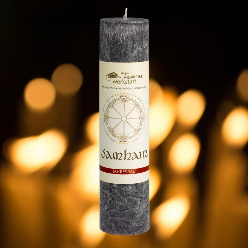 Dunkelgraue Kräuterkerze "Samhain" vor warmen Lichtern, fördert Ruhe & Entspannung in der stillen Jahreszeit.