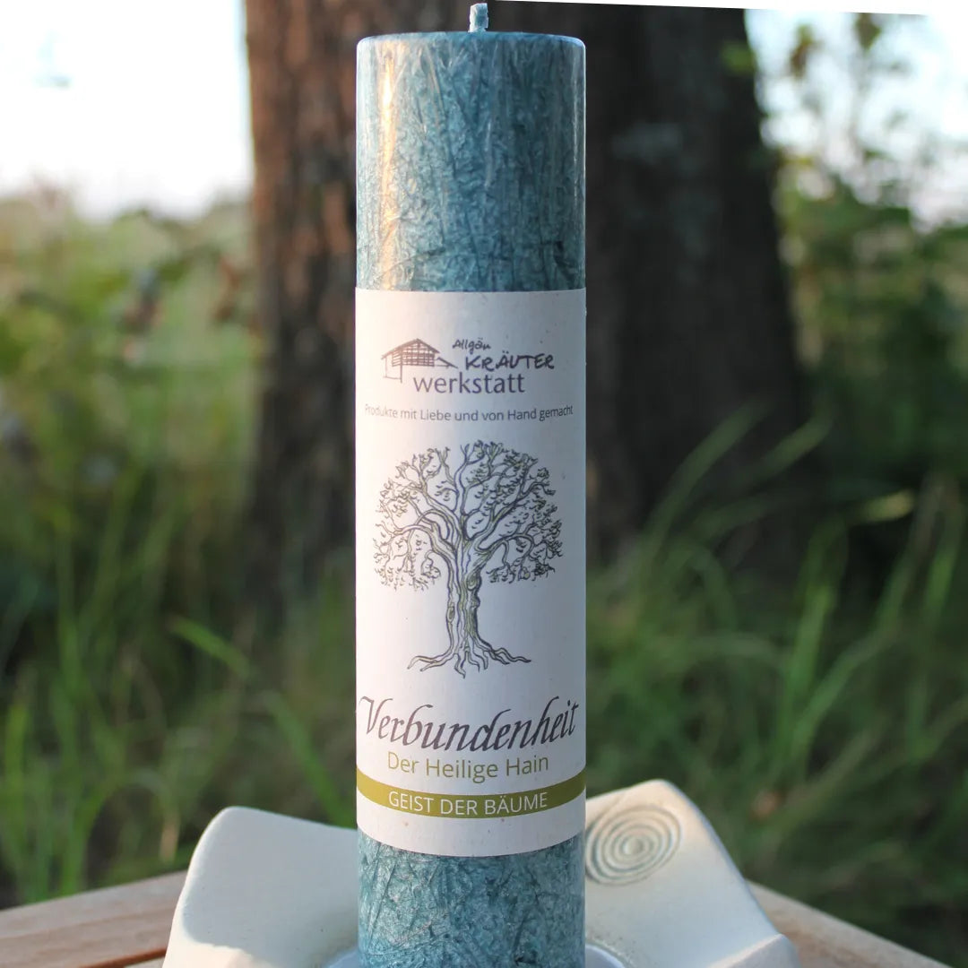 Türkise Kräuterkerze "Verbundenheit" auf Kerzenteller im Freien, hilft die Illusion der Trennung zu überwinden.