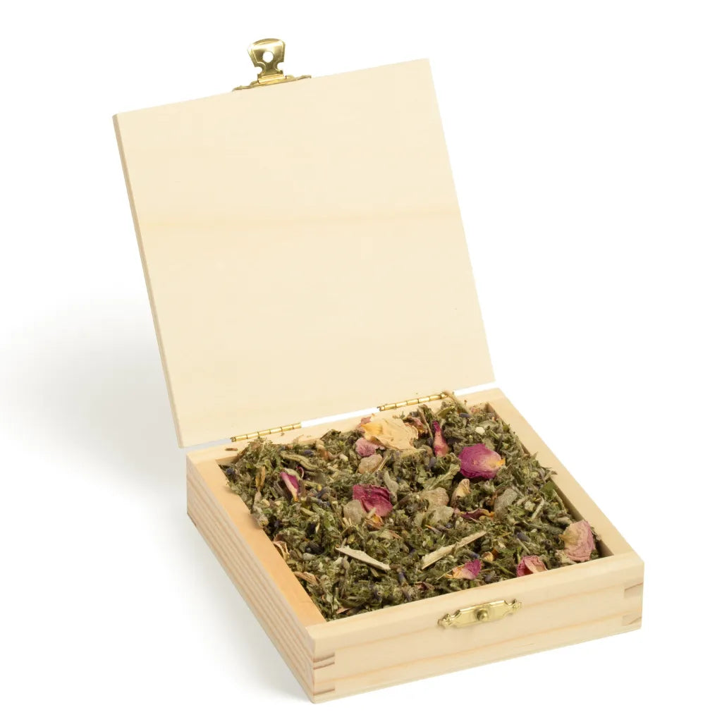 Geöffnete Holzbox "Allgäuer Räucherwerk Seelenzauber Stille" mit Räuchermischung und Rosenblüten.