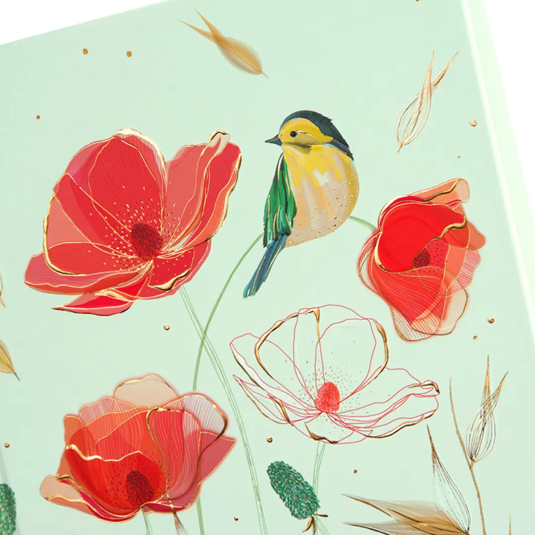 Nahaufnahme des A5 Notizbuchs 'Tender' mit Mohnblumen, Vogel und Goldprägung auf dem Cover.
