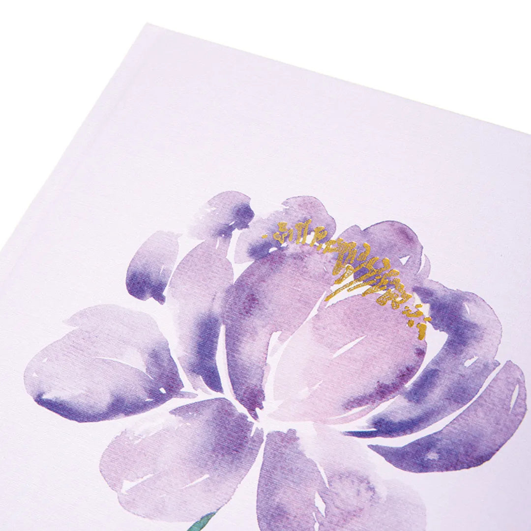 Nahaufnahme des violetten A5 Notizbuchs mit Goldprägung auf dem floralen Motiv.