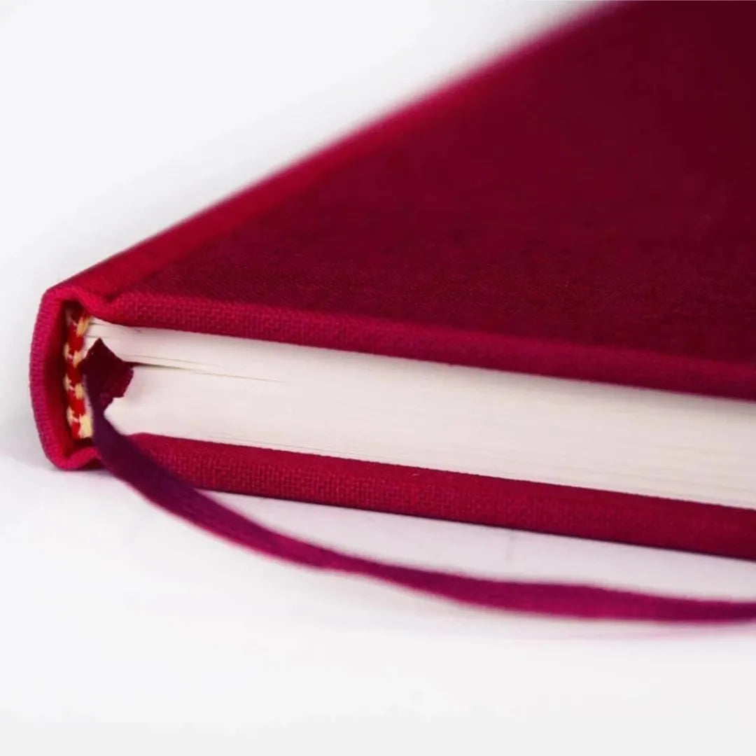 Nahaufnahme des bordeauxroten Semikolon Notizbuchs A5, zeigt Buchrücken und Leseband.