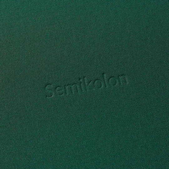 Detailansicht des dunkelgrünen Semikolon Notizbuchs A5 mit geprägtem 'Semikolon' Schriftzug.