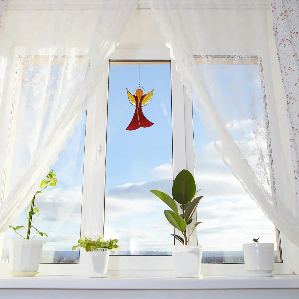 Sonnenfänger Engel in Rot-Gelb am Fenster, schafft warme Lichtakzente und eine liebevolle Stimmung im Zuhause.