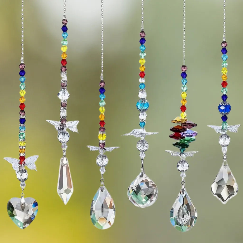 Mehrere Sonnenfänger Ketten mit Schmetterling und Regenbogenperlen hängen und erzeugen funkelnde Lichtspiele im Raum.