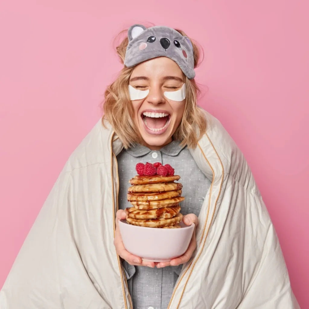 Frau lacht glücklich mit Pancakes, symbolisiert Freude, Selbstliebe und gestärktes Selbstwertgefühl.