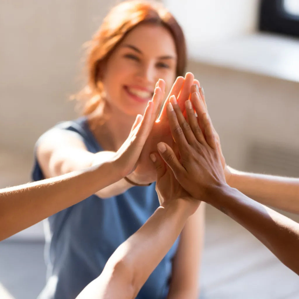 Gruppe gibt High Five, symbolisiert Motivation, Erfolg & gute Entscheidungen im Leben.