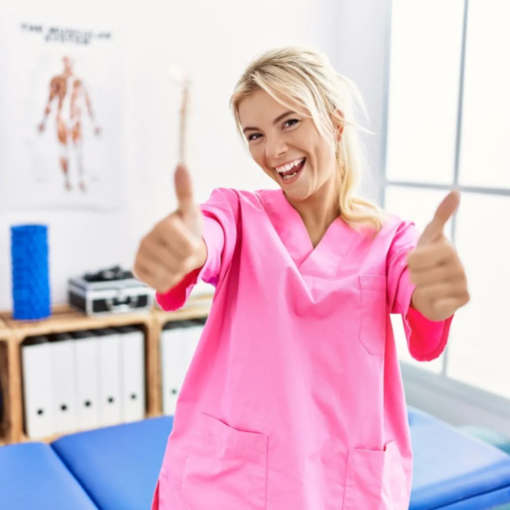 Frau in pinker Kleidung zeigt Daumen hoch, symbolisiert Gesundheit & Wohlbefinden durch Progressive Muskelentspannung.