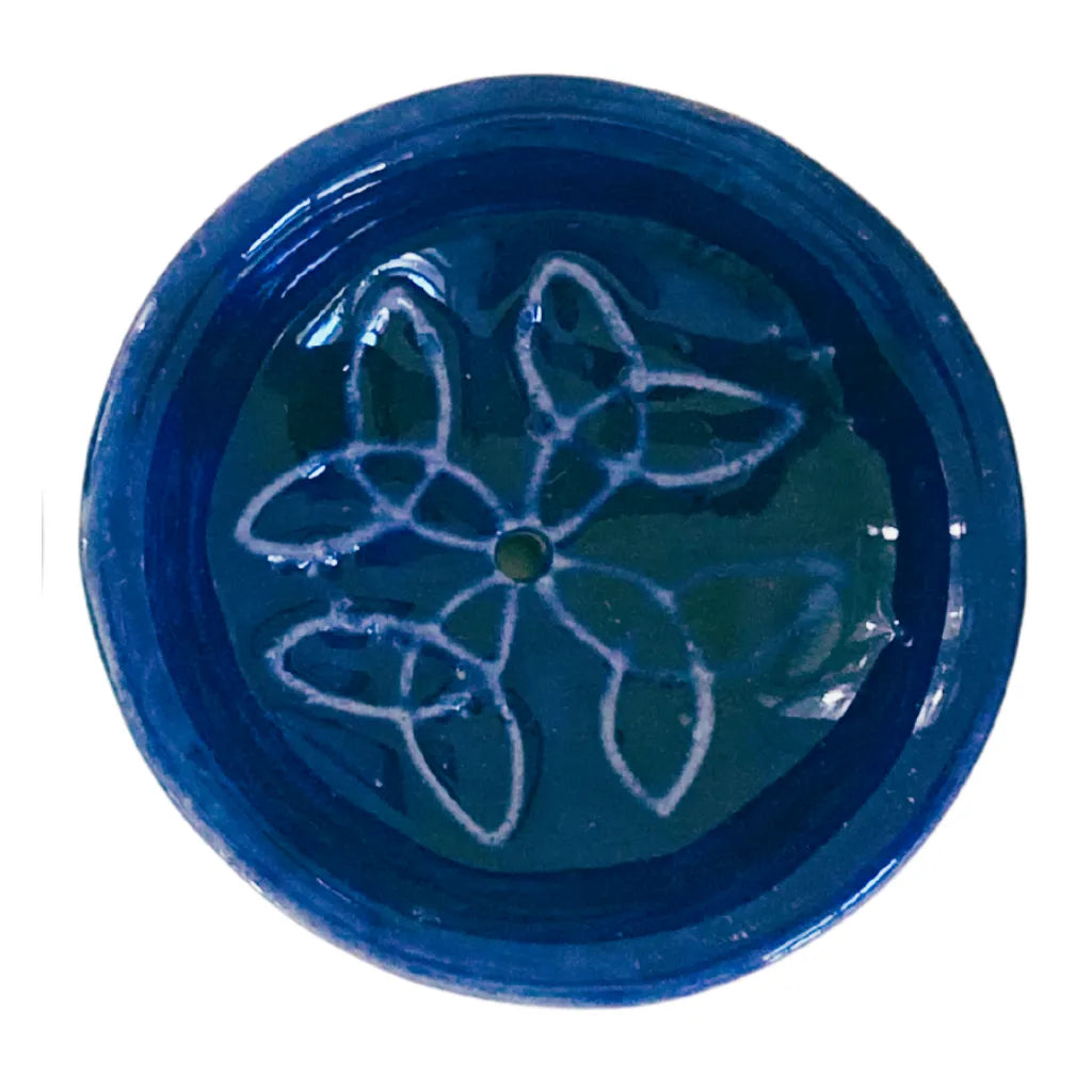 Nahaufnahme eines runden Keramik Räucherstäbchenhalters in tiefem Dunkelblau, verziert mit einem harmonischen weißen Knotenmuster und einem zentralen Loch für Räucherstäbchen.