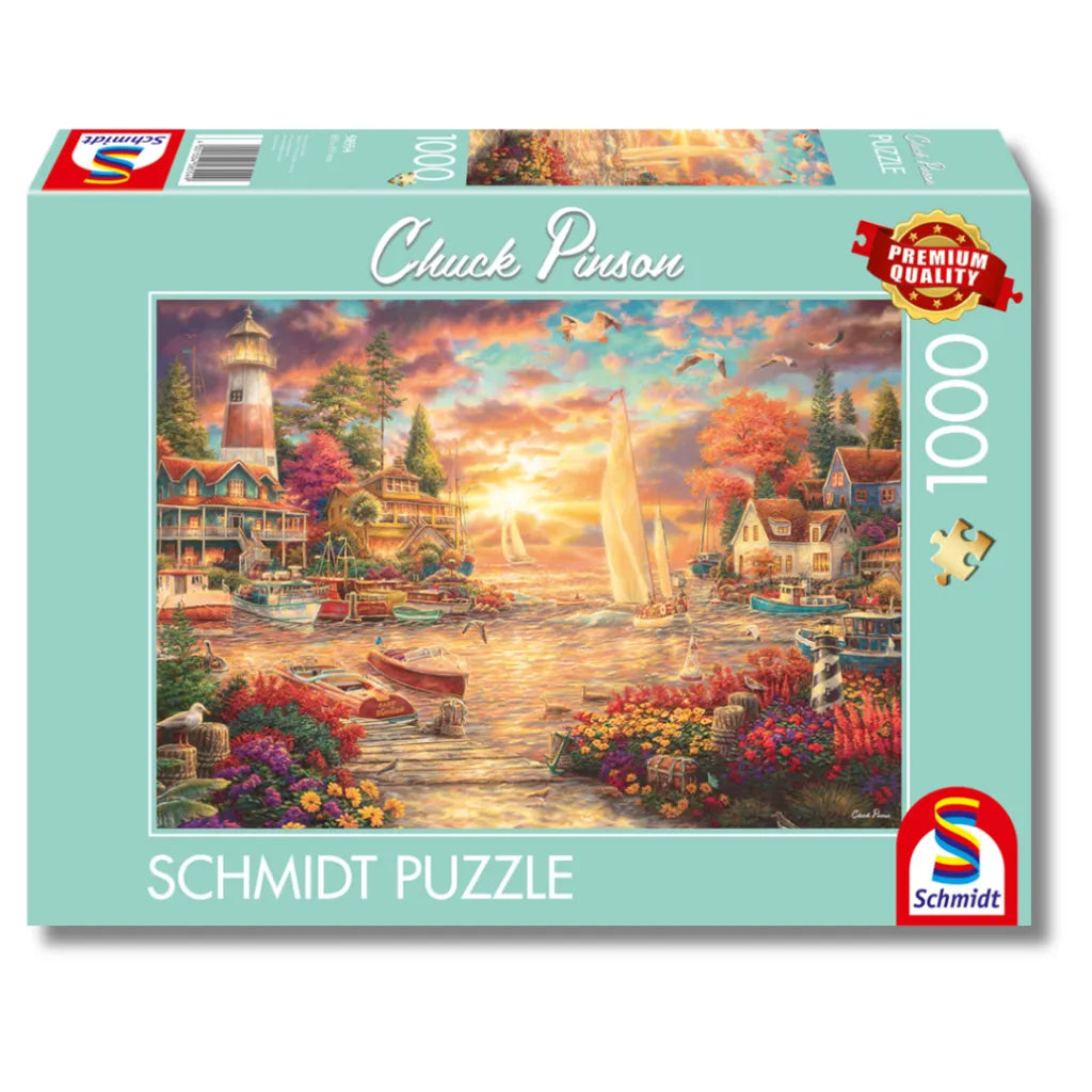 Schmidt Puzzle 1000 Teile "Morgenstille am See" von Chuck Pinson. Die Produktverpackung zeigt das Motiv mit Hafen, Leuchtturm und Booten im Morgenlicht.