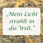 Affirmation "Mein Licht strahlt in die Welt" auf Hintergrund aus Kräutern der Räuchermischung.