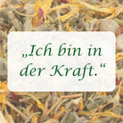 Affirmation "Ich bin in der Kraft" auf Hintergrund aus Kräutern und Blüten der Räuchermischung.
