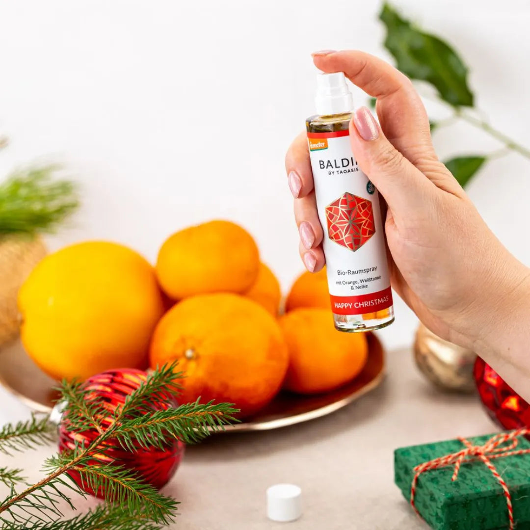 Hand hält Baldini Happy Christmas Raumspray, schafft festliche Wärme und Geborgenheit.