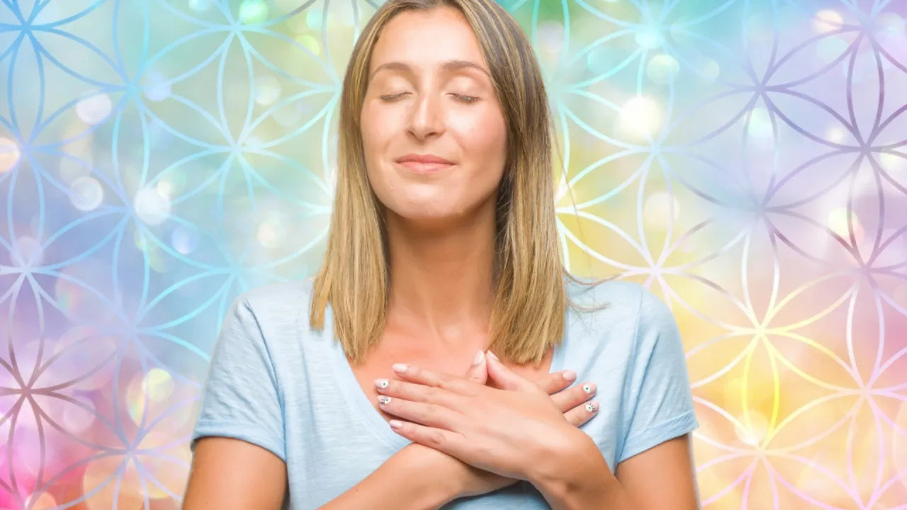 Frau mit geschlossenen Augen und Händen auf ihrem Herzen spürt in sich hinein.