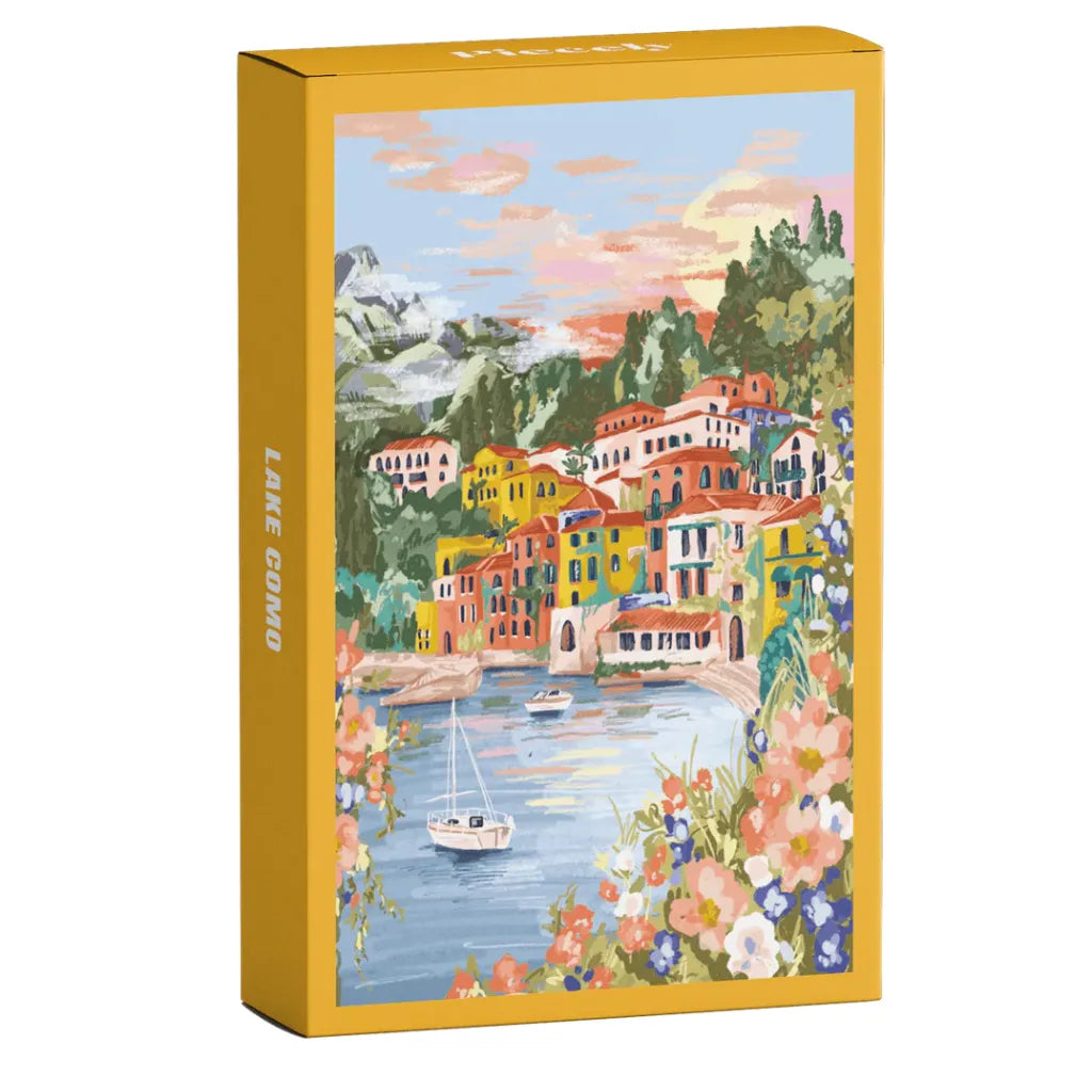 Piecely Minipuzzle 99 Teile "Lake Como" Produktverpackung. Zeigt eine farbenfrohe Illustration des Comer Sees mit bunten Häusern, Bergen, einem Segelboot und blühenden Pflanzen.