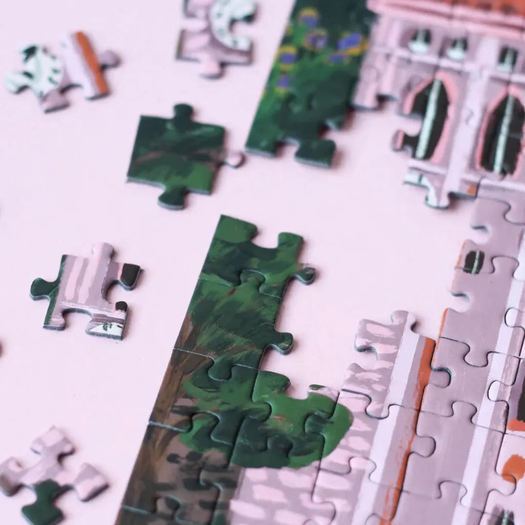 Nahaufnahme von lose liegenden und einigen bereits zusammengesetzten Puzzleteilen des Piecely Puzzles 500 "Suisse Nights". Zeigt die Vielfalt der Farben und Formen der einzelnen Teile. 