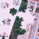 Nahaufnahme von lose liegenden und einigen bereits zusammengesetzten Puzzleteilen des Piecely Puzzles 500 "Suisse Nights". Zeigt die Vielfalt der Farben und Formen der einzelnen Teile. 