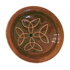 Nahaufnahme eines runden Keramik Räucherstäbchenhalters in warmem Dunkelbraun, verziert mit einem harmonischen weißen Knotenmuster und einem zentralen Loch für Räucherstäbchen.